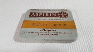 Aspirina firmy Bayer z okresu międzywojennego. Tabletki znajdują się w metalowym pudełku. Lek ma działanie przeciwgorączkowe i przeciwbólowe.